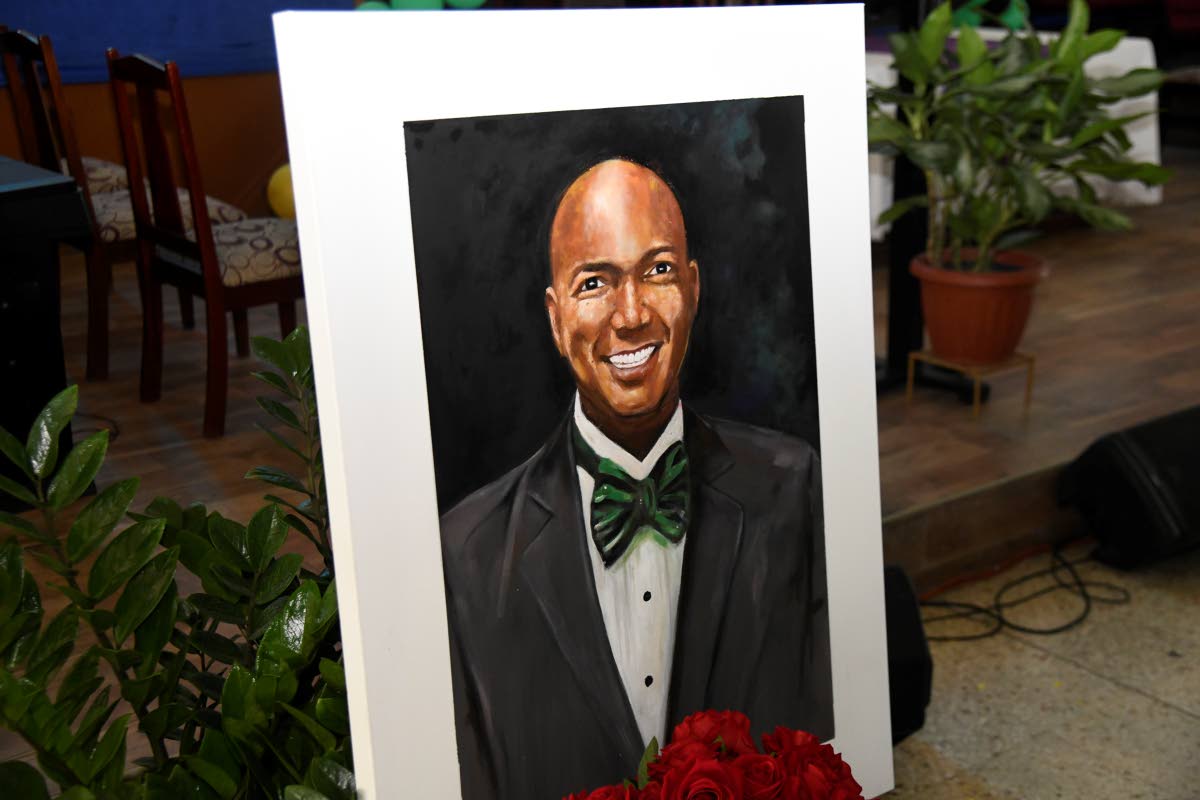 A portrait of Dervan Malcolm at his remembrance service held yesterday at the Boulevard Baptist Church in St Andrew.