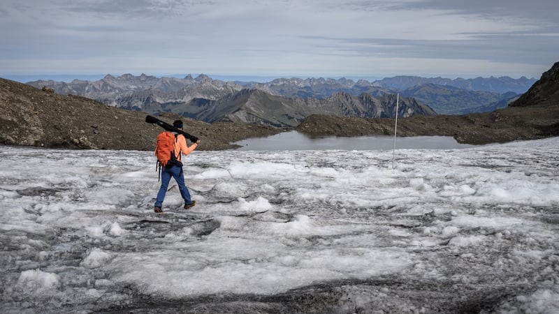 Matthias Huss, head of the "Glacier Monitoring in Switzerland" (GLAMOS) network, walking towards a measuring stake during a visit to record changes in the melting Scex Rouge glacier